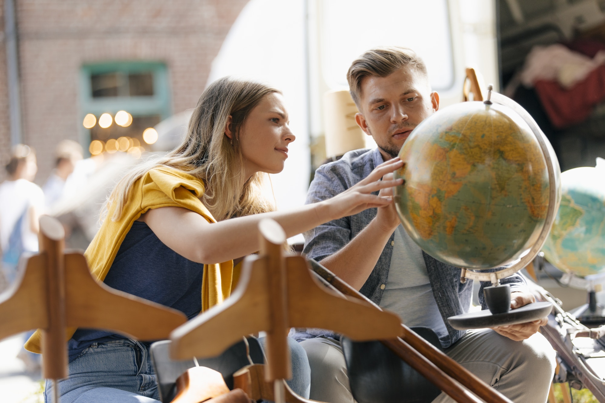 Belgium, Tongeren, young couple examining globe on an antique flea market